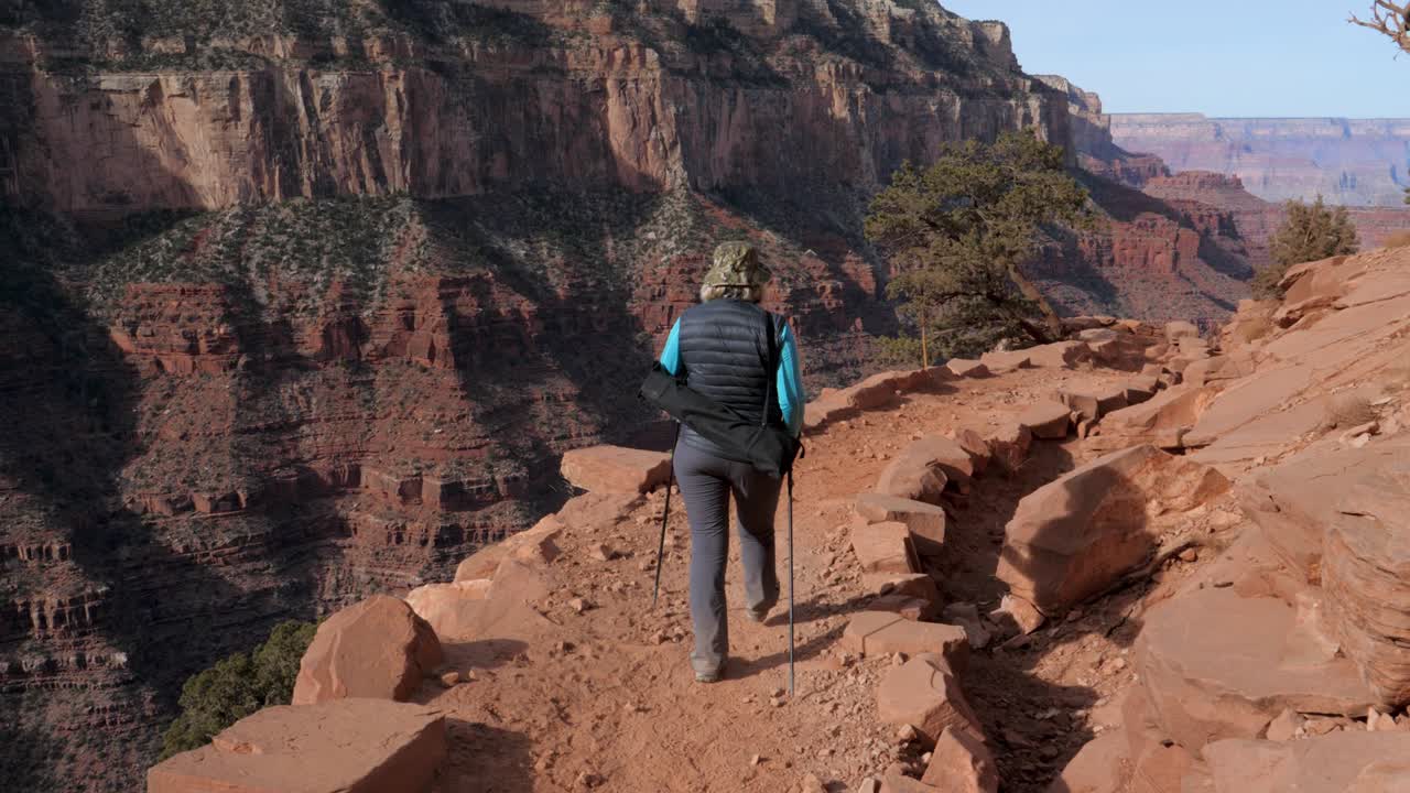 una mujer caminando en el gran cañón.