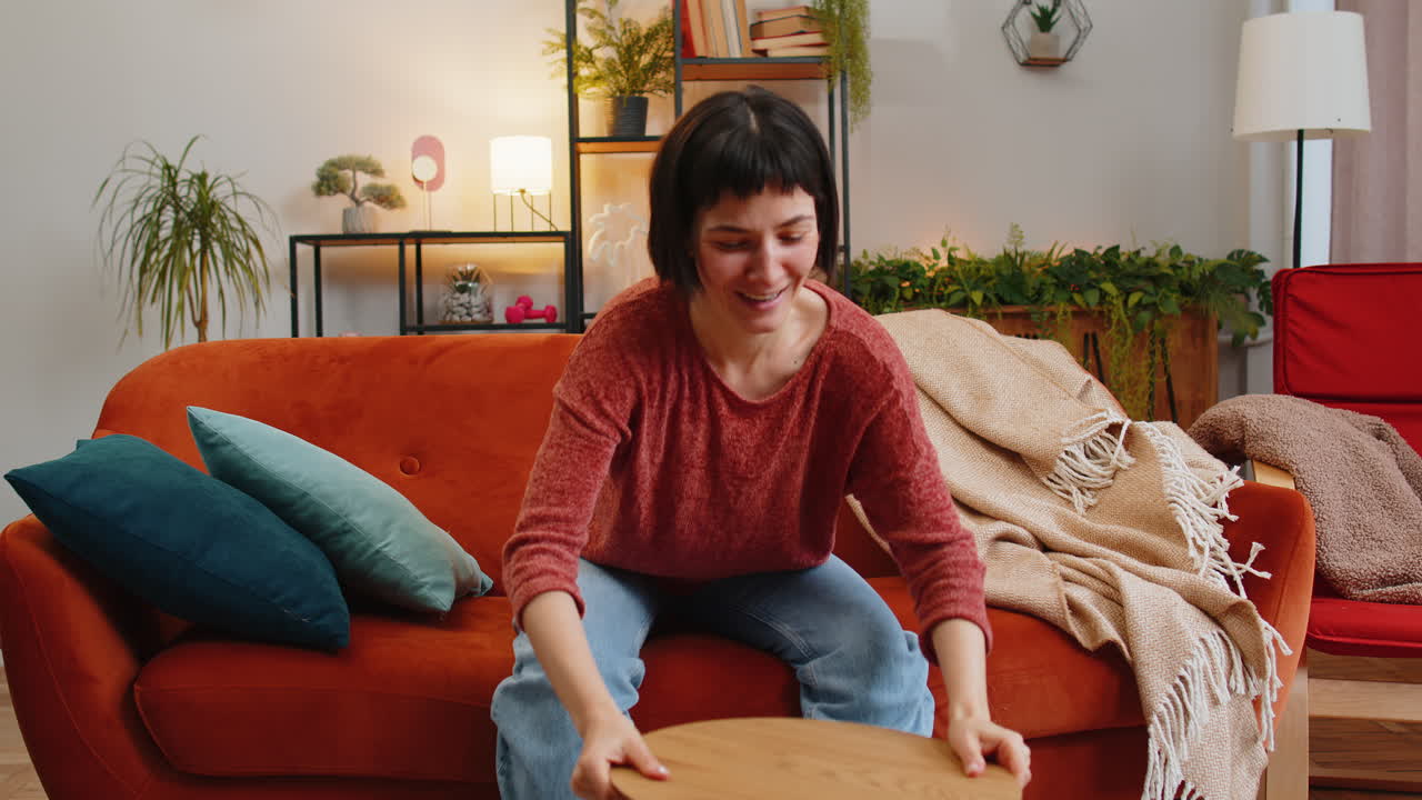 Excited woman finishing assembling furniture table collect repair fixing at couch in home room