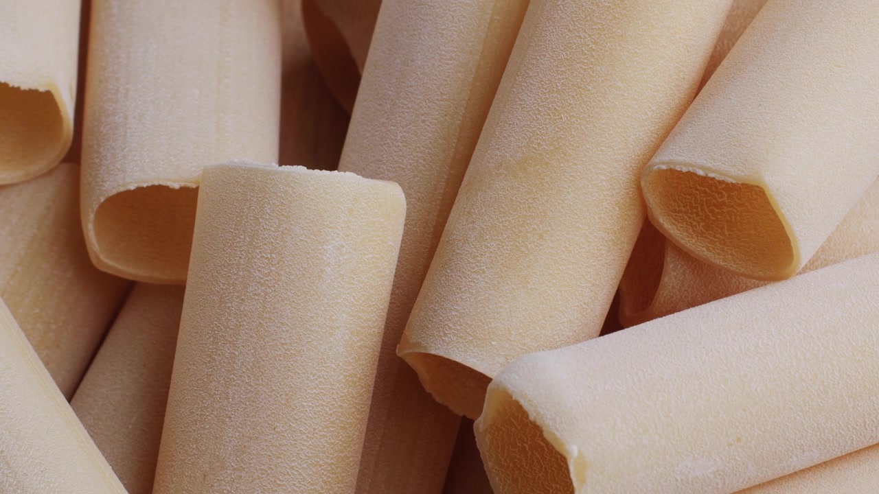 Lähikuva kuivista keittämättömistä cannelloni-pastaputkista