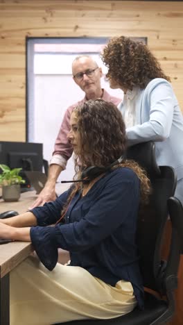 Manager explaining task to telemarketer at office. Vertical footage