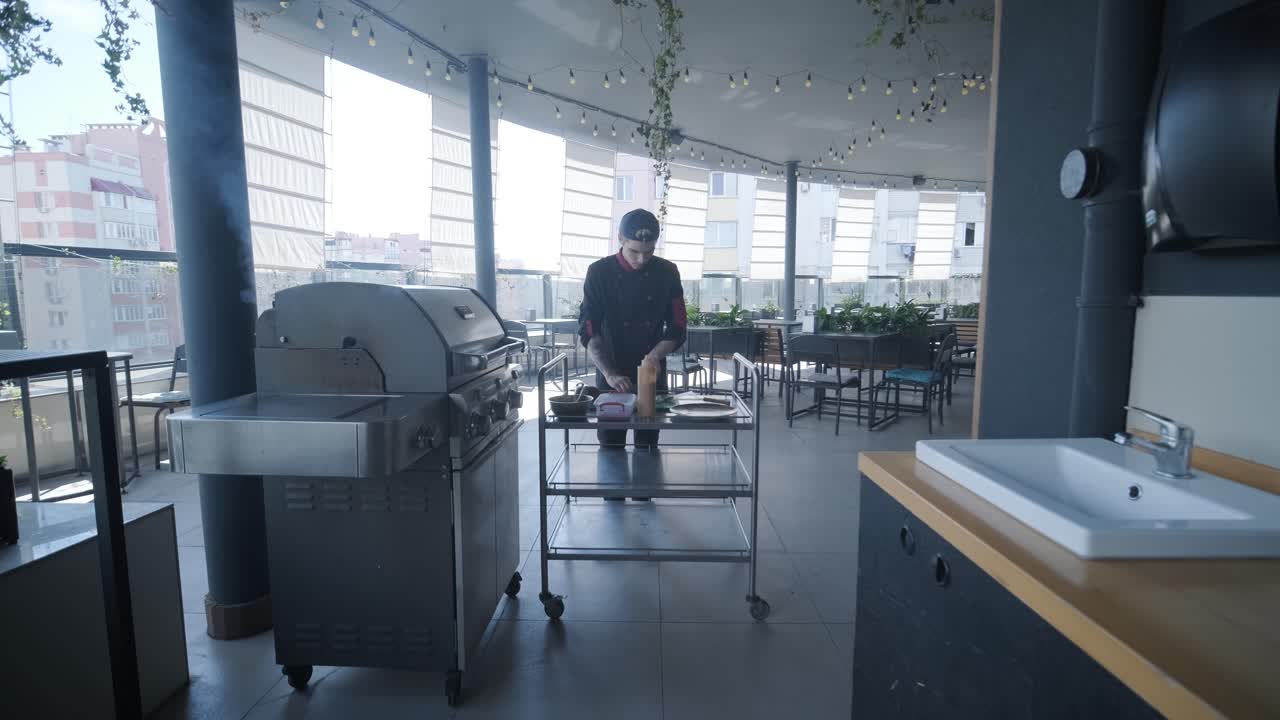 el chef de un restaurante en la azotea preparando comida.