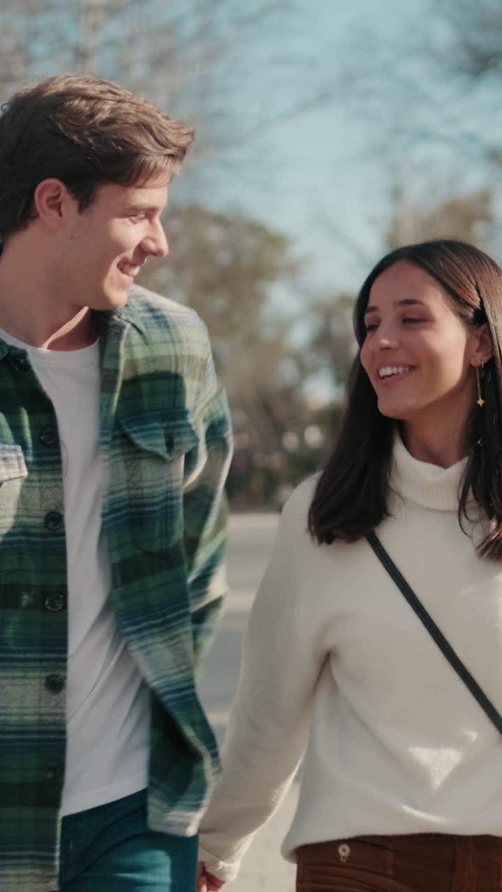 Happy young couple man and woman walking down the street talking and hugging