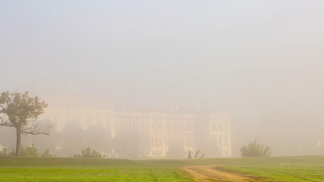 Timelapse-shot-of-gravel-path-leading-upto-Jelgava-Castle-in-Latvia-surrounded-by-dense-fog-during-morning-time