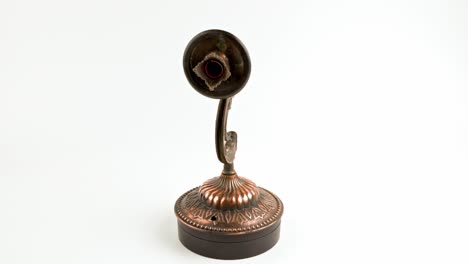 una parrilla de bronce falsa girando en una mesa giratoria sobre un fondo blanco