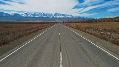 empty road leading to snow-capped mountains