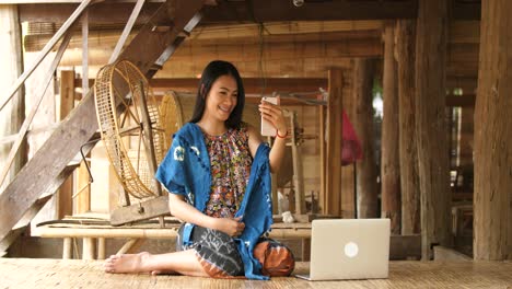 woman in traditional clothes taking a selfie in a rural village