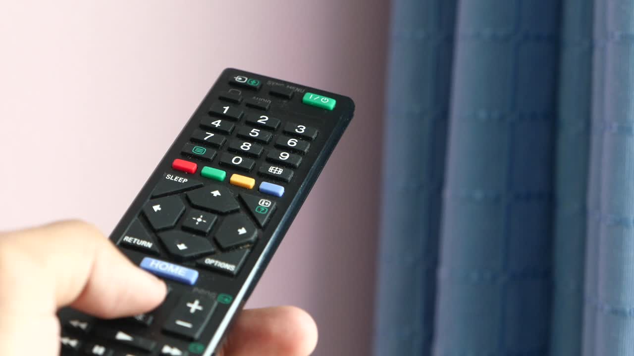 tv 리모컨을 들고 있는 손