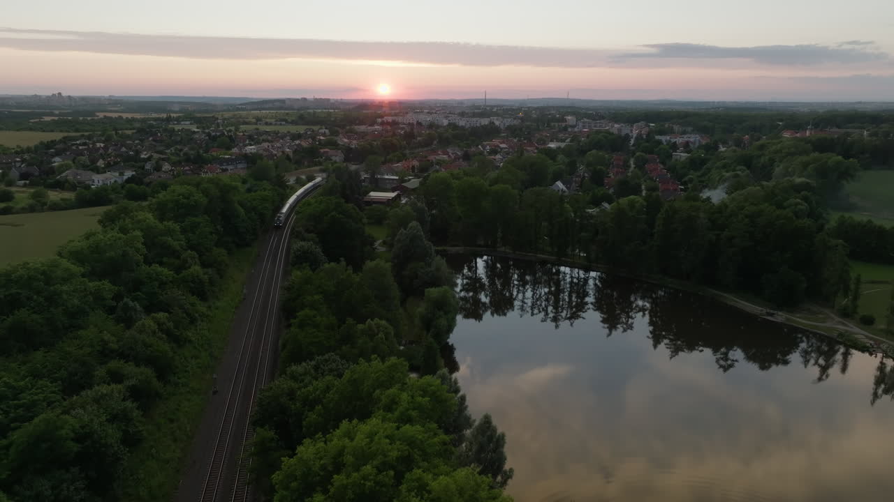 푸른 시골 을 지나가는 기차 의 해 가 지는 공중 풍경