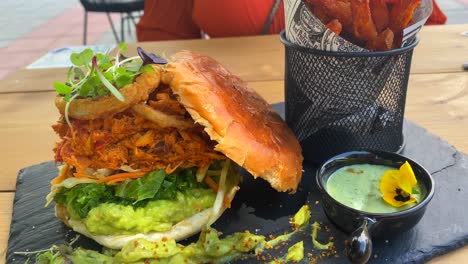 pulled chicken burger with onion rings, avocado, crispy kale, brioche bun and sweet potato french fries, food restaurant, 4k shot