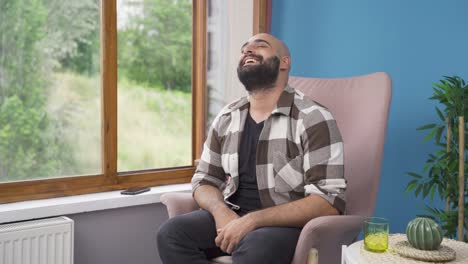 el hombre feliz mira por la ventana y respira profundamente.