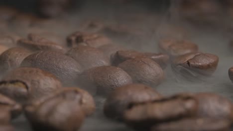 primer plano macro de asar granos de café en un horno caliente, humo espeso que sale de los granos a medida que se agrietan y se doran para darle al barista el sabor deseado perfecto