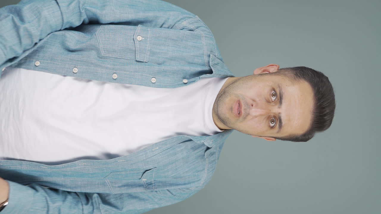 video vertical de la reacción de miedo del hombre mirando a la cámara. hombre cobarde.