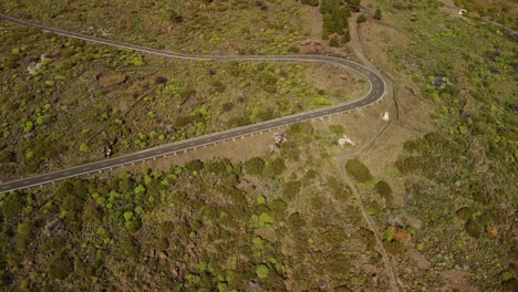View-at-curvy-empty-road-in-hills-surrounded-by-green-nature