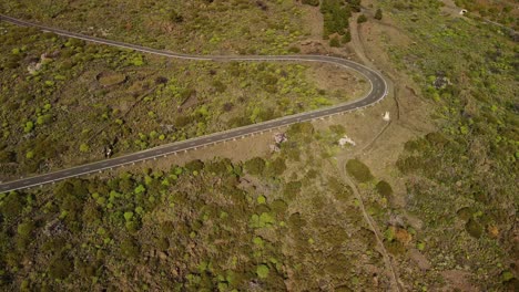 en vista de una carretera vacía curva en colinas rodeadas de naturaleza verde