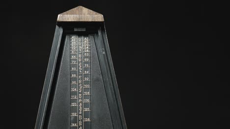 close-up shot of vintage metronome with golden pendulum