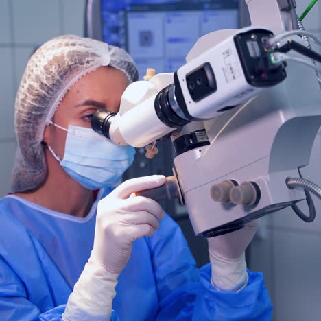 female doctor during laser eye surgery. ophthalmologist performs an operation on eye with the help of microscope in clinic.