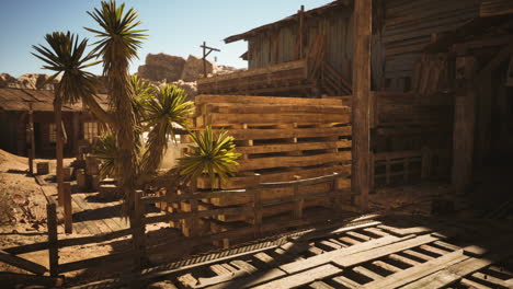 deserted wooden structures in an abandoned western town under bright sunlight