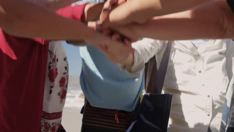 volunteers forming hand stack on the beach 4k