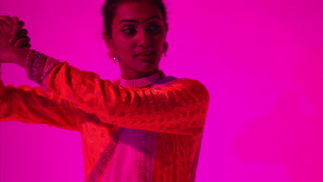 Waist-Up-Studio-Shot-Of-Female-Kathak-Dancer-Performing-Dance-Wearing-Traditional-Indian-Dress-Against-Purple-Background-4