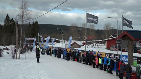cross country skiers arriving at a stop at worlds largest cross country ski race vasaloppet, establishing shot