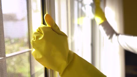 Hand-In-Yellow-Rubber-Gloves-Cleaning-And-Wiping-Window-With-A-White-Rag