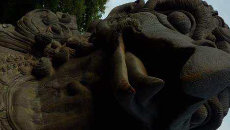 vertical close up dolly forward shot of the garuda bird statue at the gwk cultural park in bali