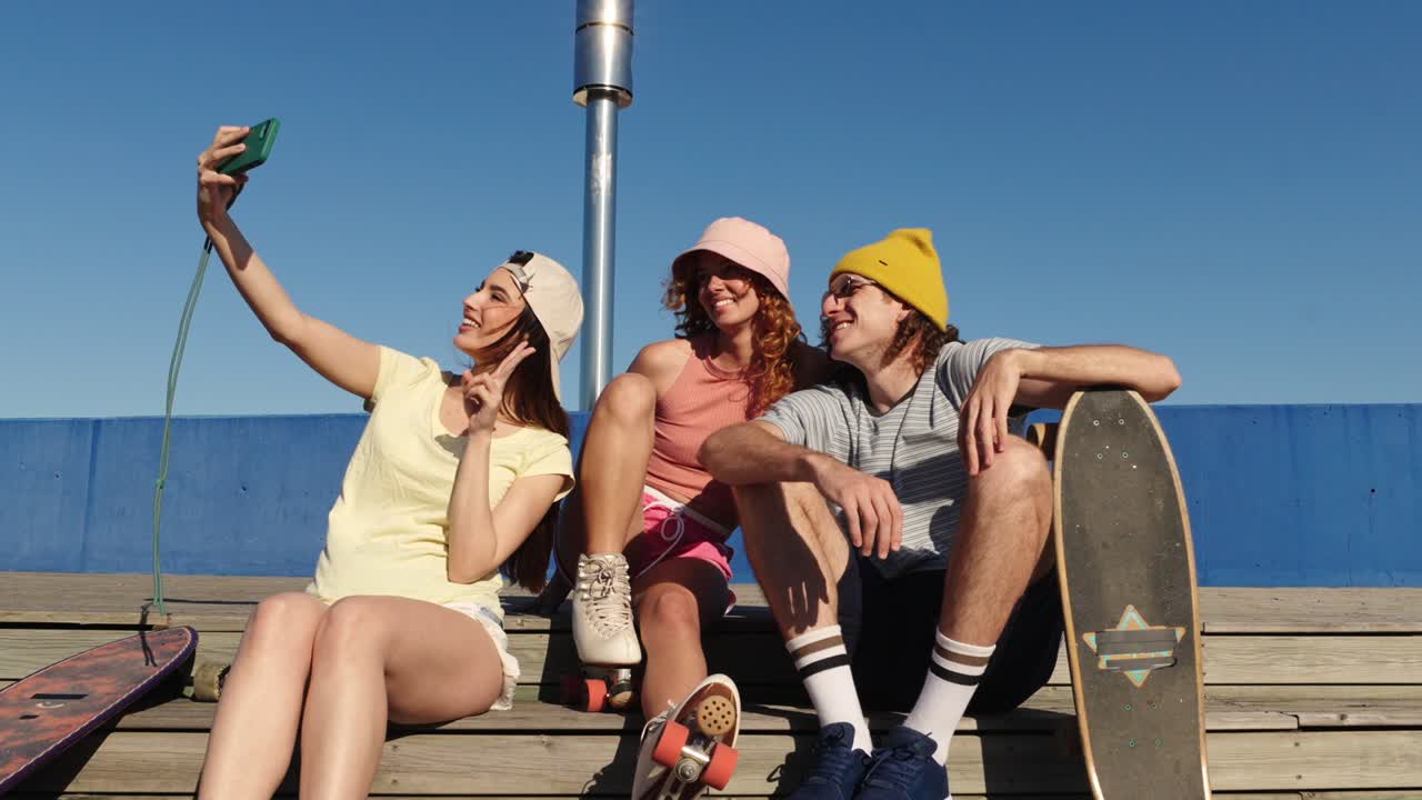 Gruppo di amici che si fanno un selfie con skateboard e pattini a rotelle