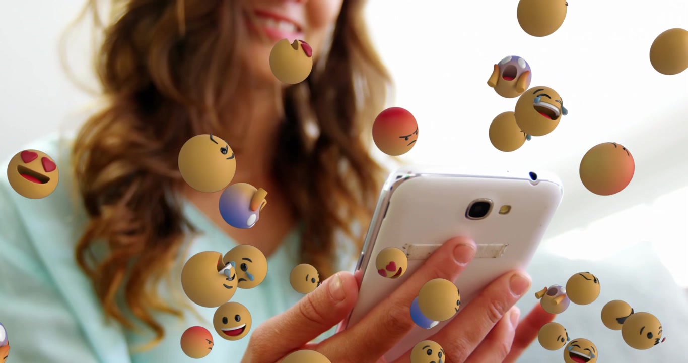Animation af flere ansigtsemojis svævende over kaukasisk kvinde, der bruger smartphone på kontoret.