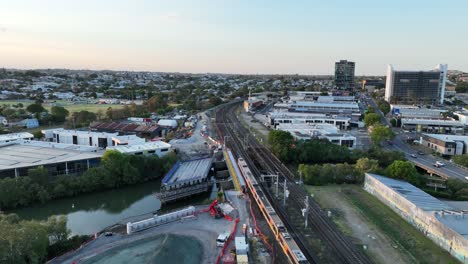 Drohnenschuss-Verfolgt-Den-Zug,-Der-Den-Bahnhof-Brisbane-City,-Mayne,-überquert