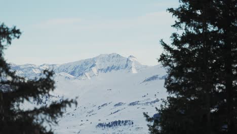 Aerial-shot-at-sunrise-displaying-the-silhouette-of-a-snow-covered-mountain-range