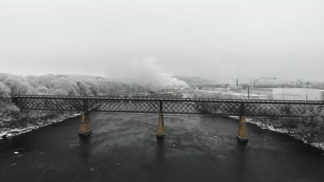 puente fluvial y presa en invierno rodeados de árboles cubiertos de escarcha