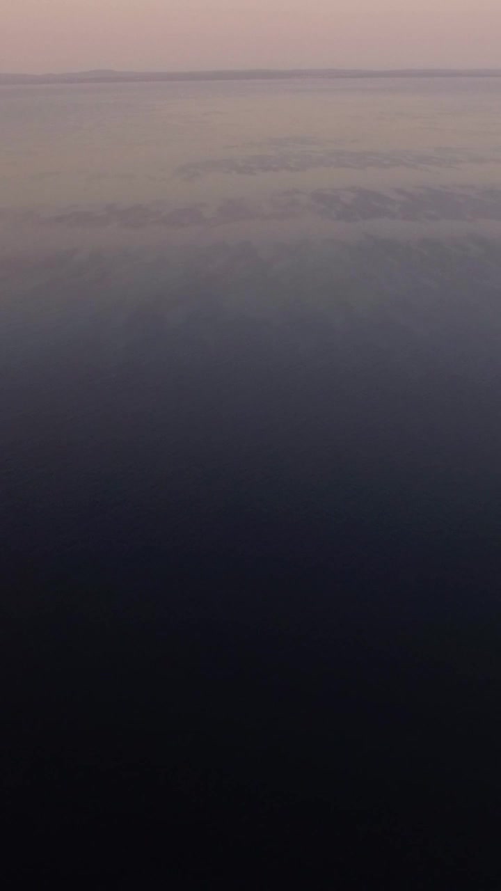 Vast sea with sailing motor boat in the distance