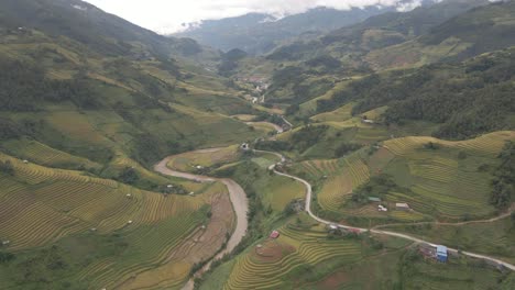 el dron avanza sobre el río y el camino ventoso a lo largo de la empinada escalera de los arrozales