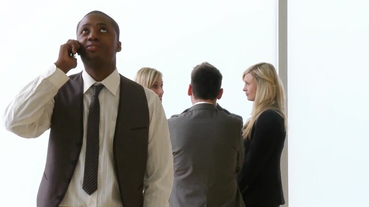AfroAmerican businessman on phone with his colleagues in the background footage