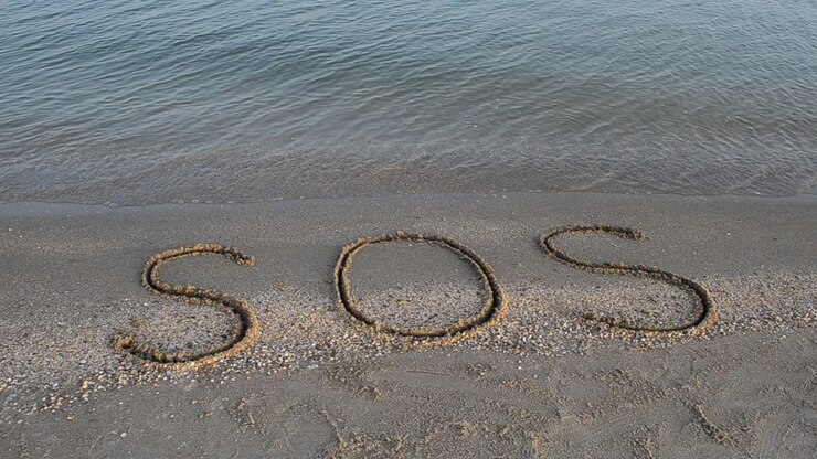 The inscription SOS on sand. Shooting on the beach