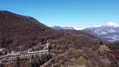 consonno un 'pueblo fantasma' de olginate, lecco, en lombardía, vegetación y montañas cubiertas de nieve en el fondo