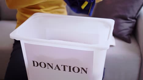 detail of woman selecting clothes for donation