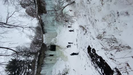 Vertical-travel-video-of-frozen-Minnehaha-Falls,-winter-landscape