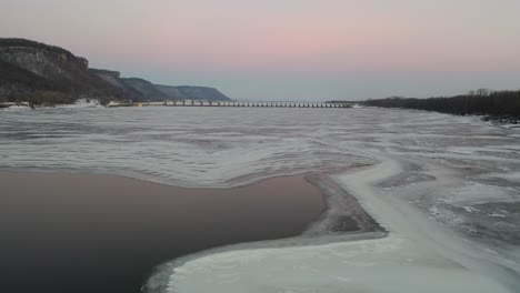 bevroren rivier met dam bij zonsopgang of zonsondergang