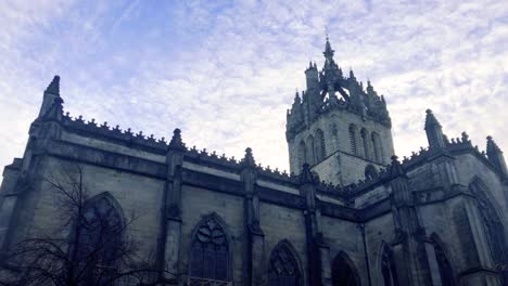nubes que se mueven lentamente sobre una iglesia y una estatua, en un día frío y nublado en escocia