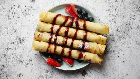 Plate-of-delicious-crepes-roll-with-fresh-fruits-and-chocolate