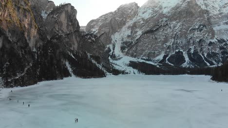 Inclinación-Aérea-Lenta-Hacia-Arriba-De-Un-Paisaje-Invernal-Sobre-El-Lago-Congelado-Braies-En-Los-Dolomitas-Italianos