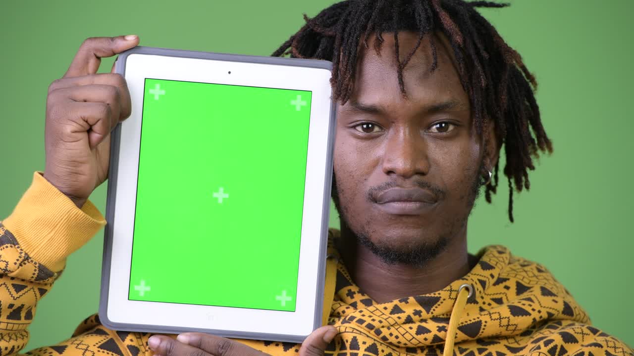 Ung flot afrikansk mand viser digital tablet