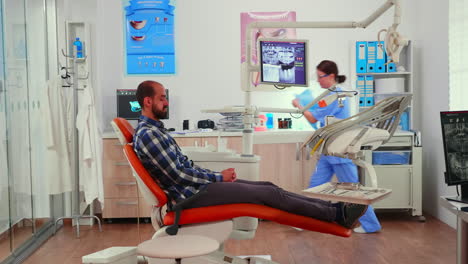 nurse putting dental bib to man before stomatological examination