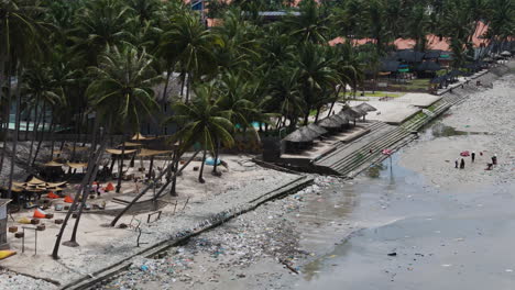 aerial view of people working and cleaning beach full of pollution, waste and rubbish - climate catastrophe on earth