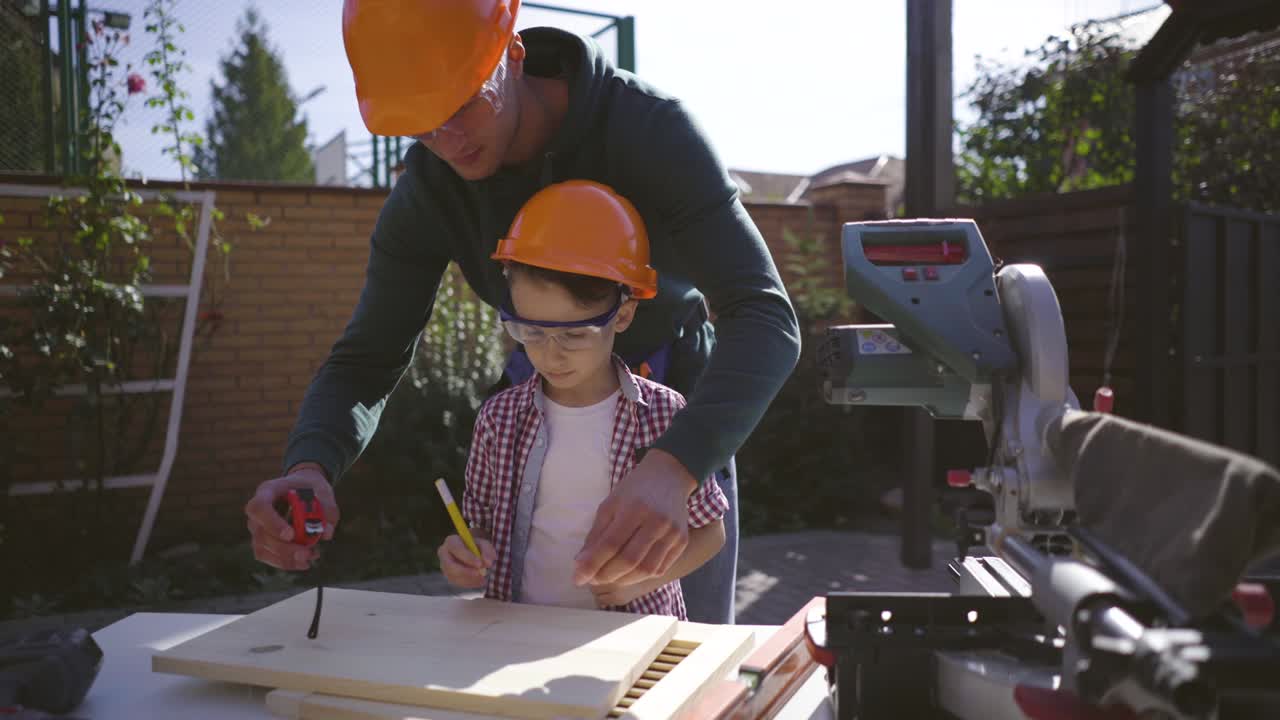 el padre enseñando a su hijo pequeño carpintería