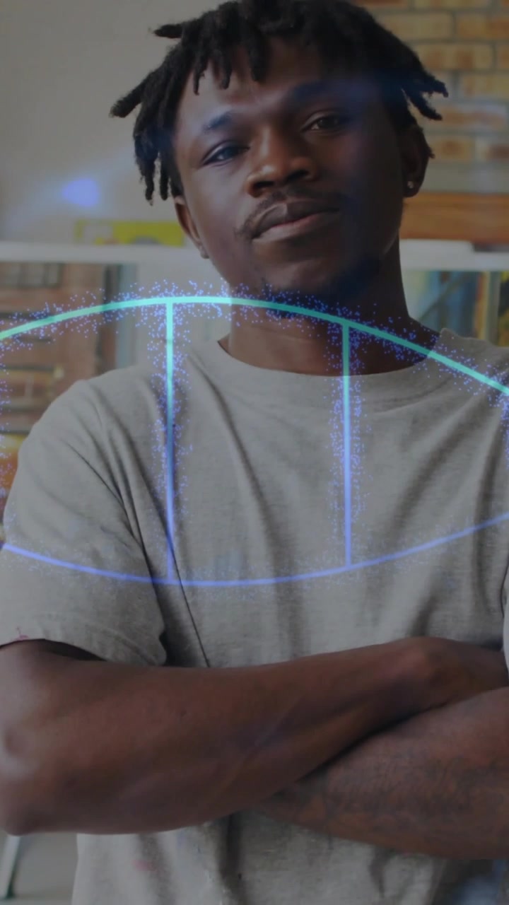 Vidéo verticale : Homme dans un environnement technologique, ajustant puis croisant les bras, tandis qu'une superposition bleue balaye l'écran, montrant le calme.