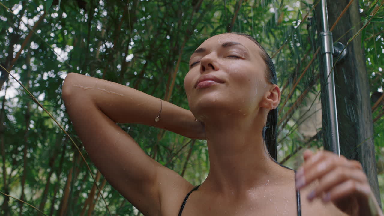 mujer hermosa en la ducha usando bikini lavando el cuerpo limpiando la piel con agua refrescante disfrutando de la belleza natural spa duchándose al aire libre en la naturaleza