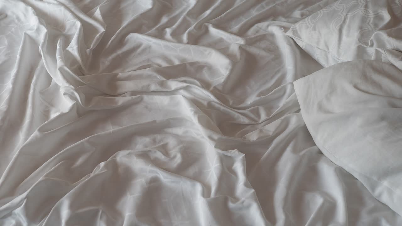 непостроенная кровать с морщинистыми простынями