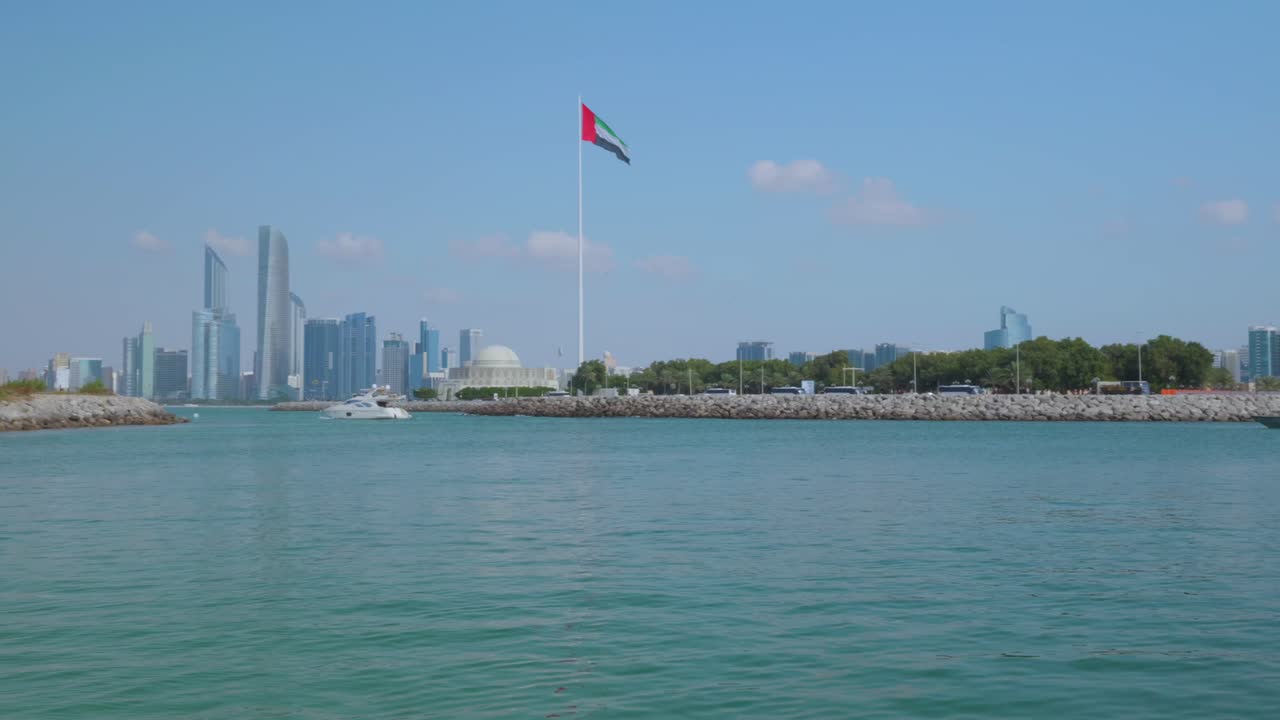 pan shot og el horizonte de abu dhabi y la bandera de los emiratos árabes unidos